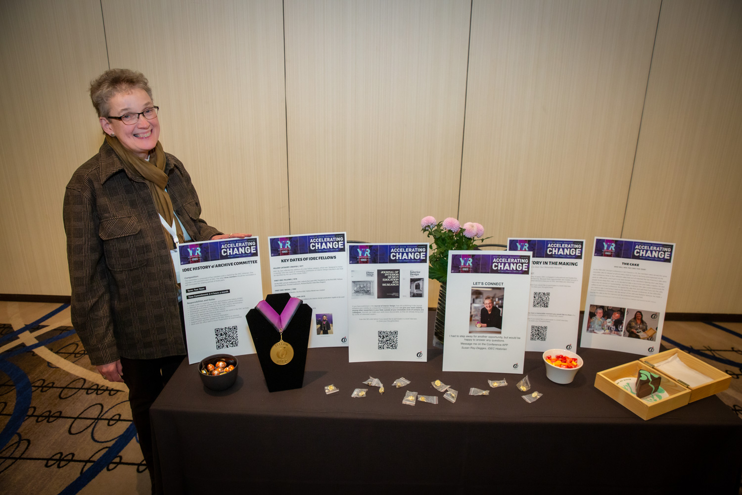 Woman smiling next to table of conference materials