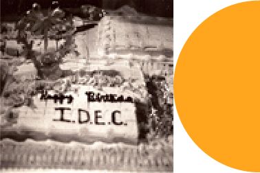Old photo of an IDEC sheet cake next to a half orange circle