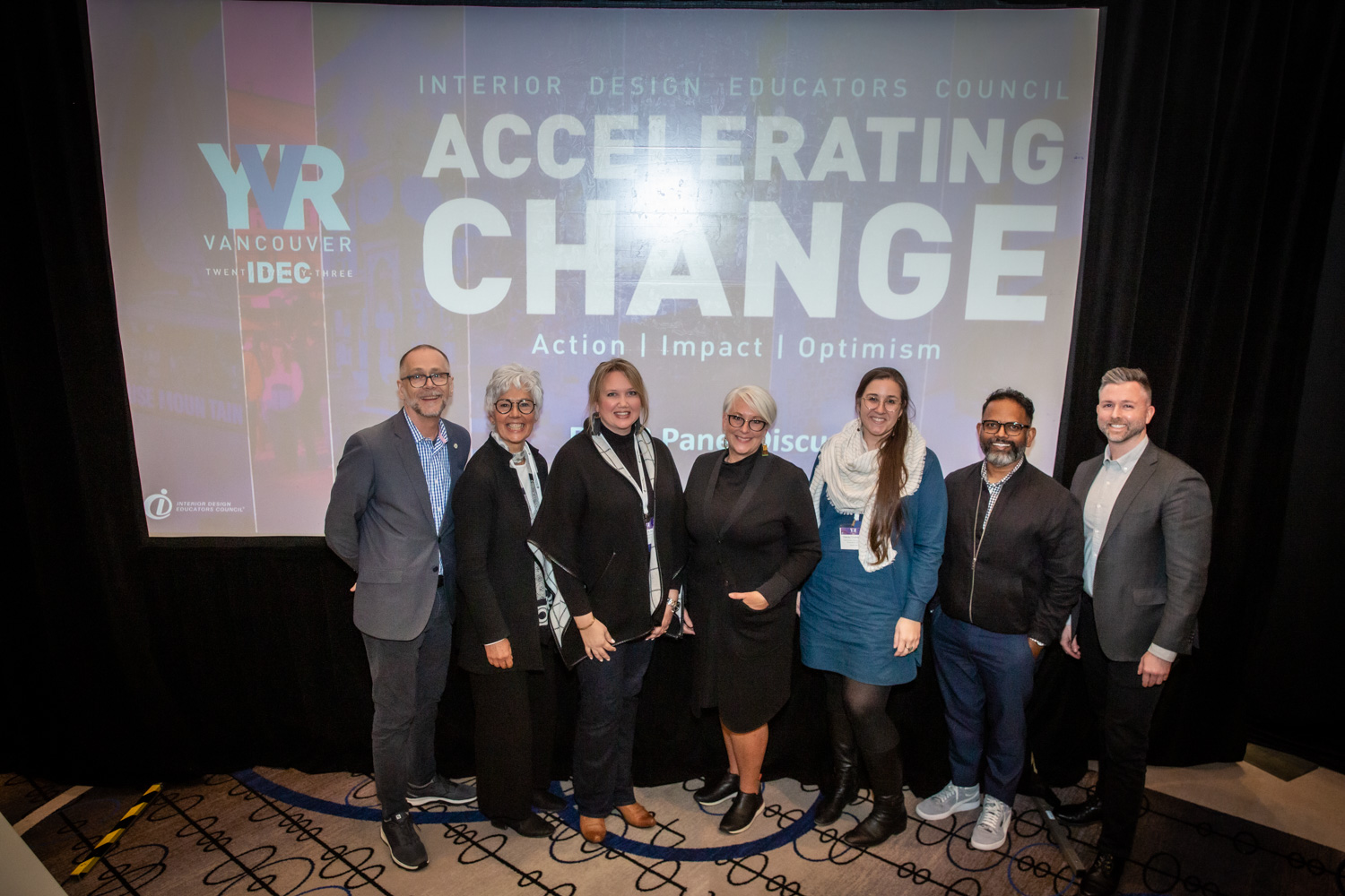 Accelerating Change conference panelists standing in front of projector screen/
