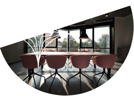 Half circle shape with a photo of a conference table within it and a white diamond graphic