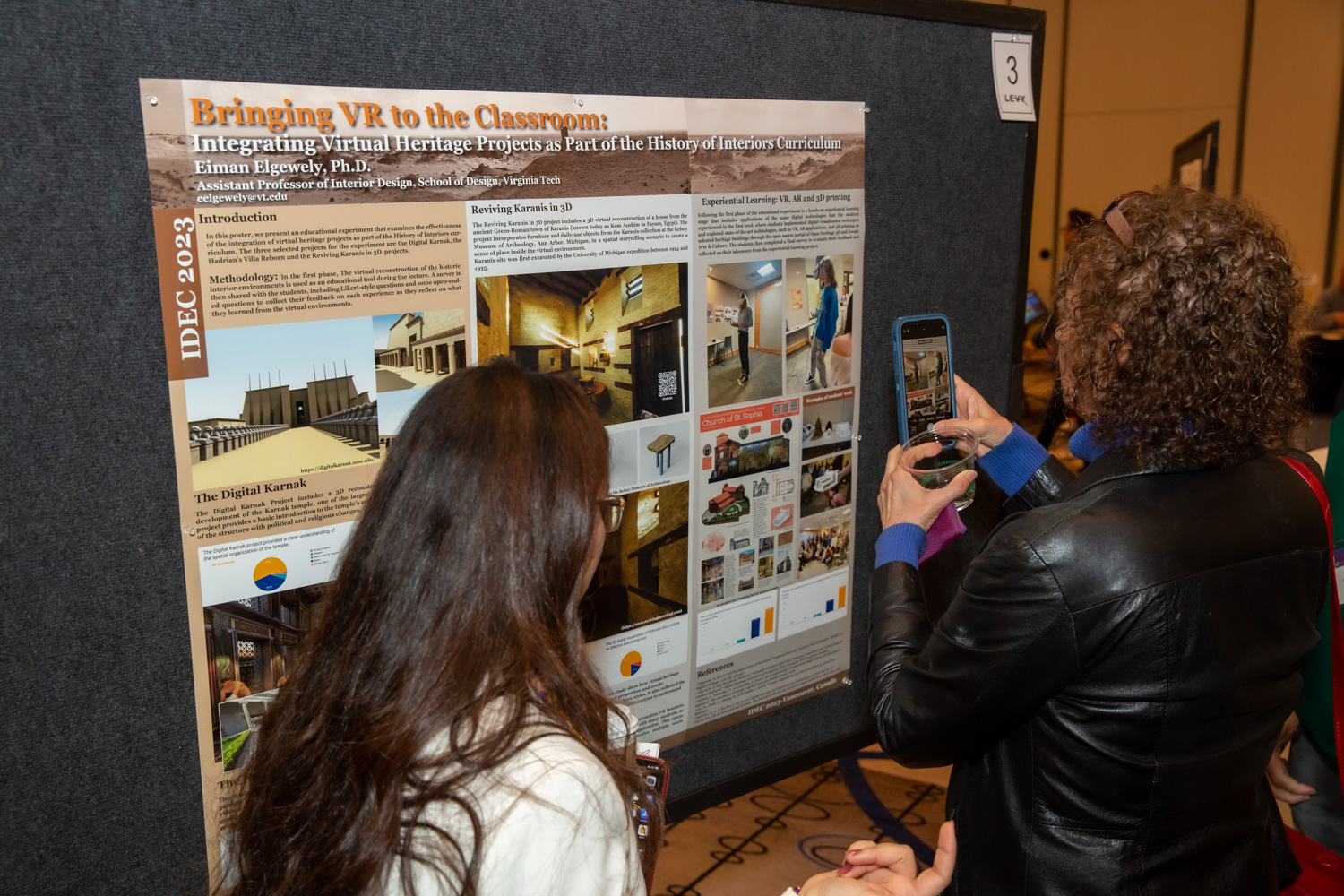 Conference-goers taking a picture of a poster.